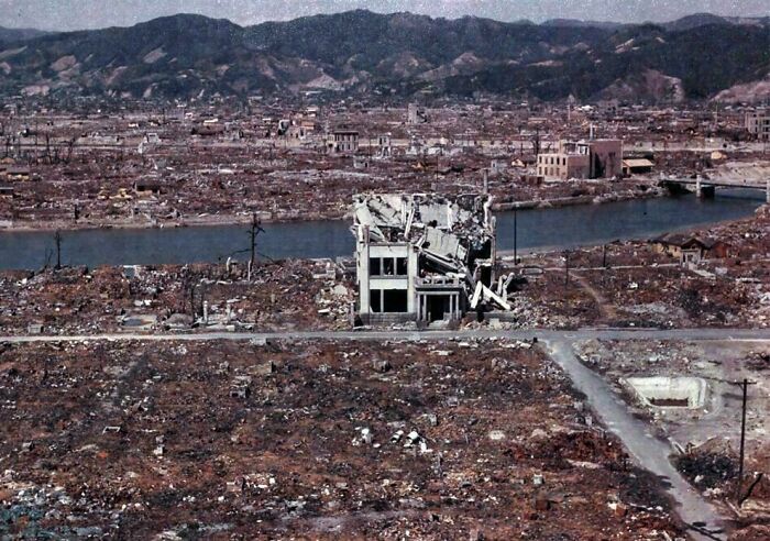 Desolate cityscape showing ruins and debris with a single damaged building standing near river