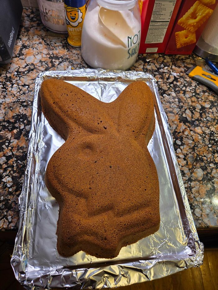 Bunny-shaped cake on foil-lined tray in kitchen for dessert