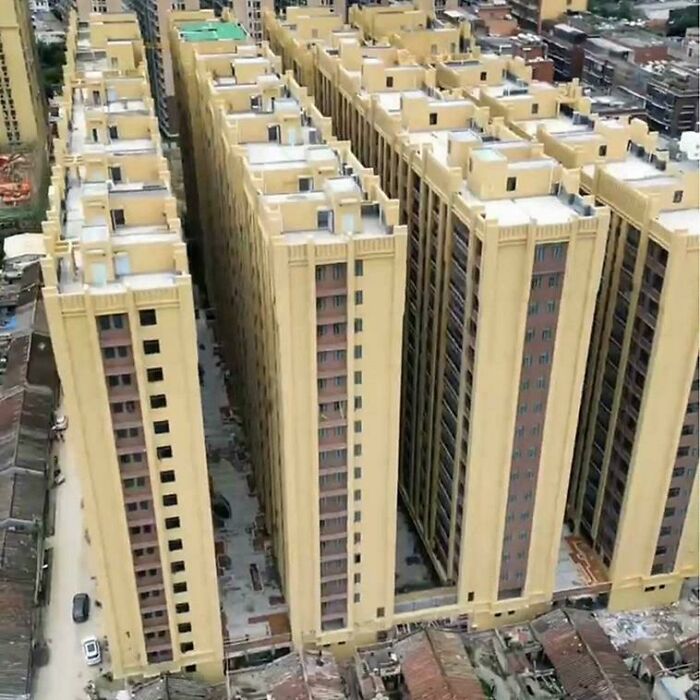 Aerial view of dense cluster of beige multi-story apartment buildings in urban area