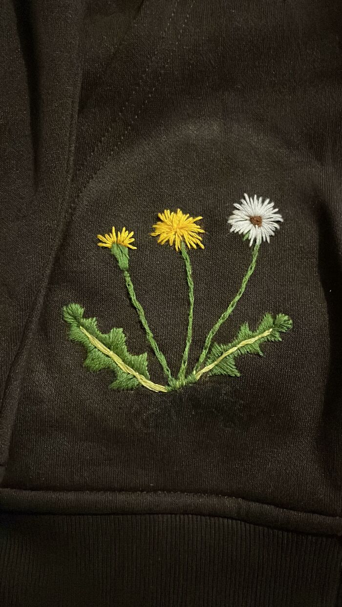 Close-up of a delicate embroidery creation featuring dandelions on dark fabric, perfect for new hobbies.