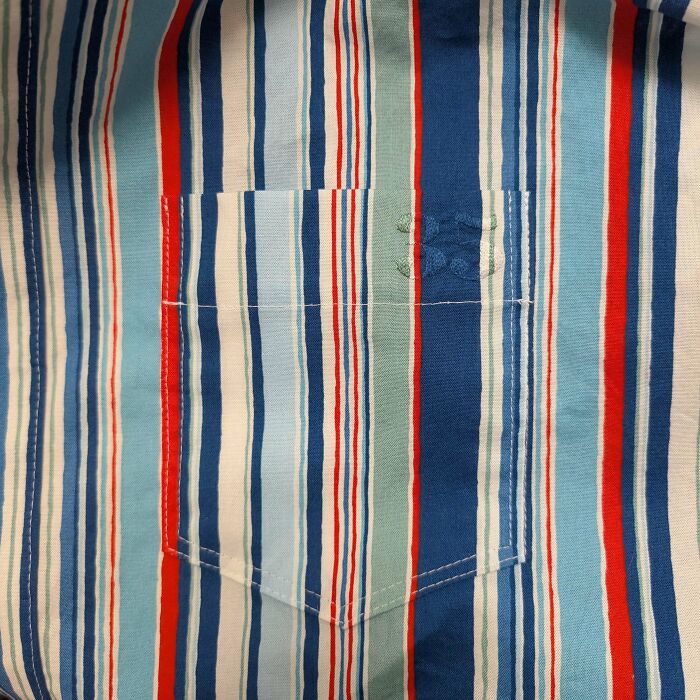 Stunning embroidery creation on a striped shirt, featuring a subtle green design on the pocket, inspiring a new hobby.