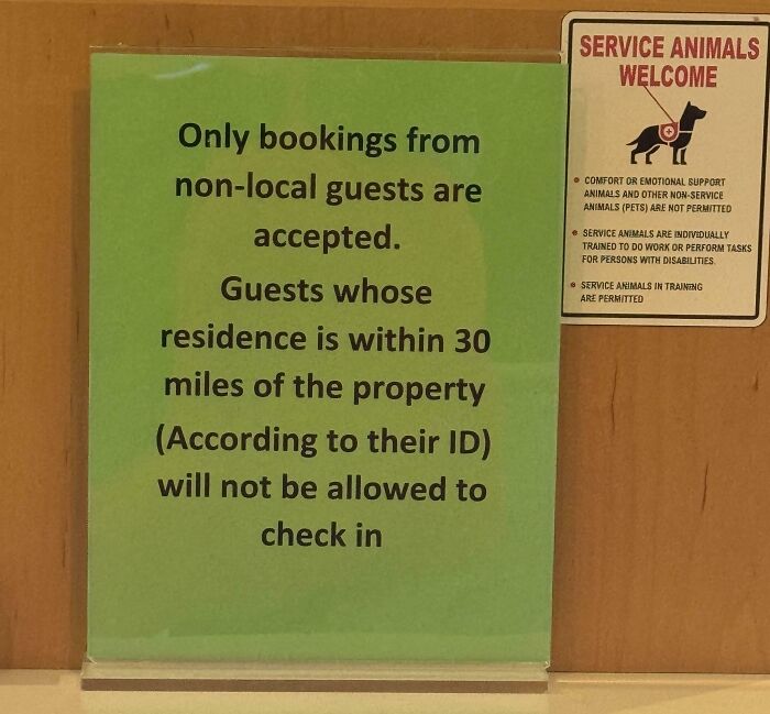 Signs with oddly specific rules: a green sign limits bookings to non-local guests and a smaller sign welcomes service animals.