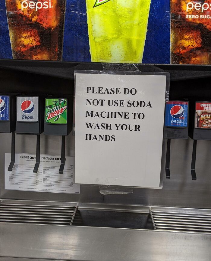 A soda machine with a sign: PLEASE DO NOT USE SODA MACHINE TO WASH YOUR HANDS, an oddly specific rule.