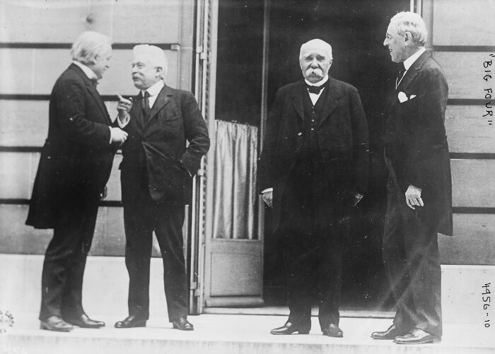 Rare and interesting photo of four historical figures in formal attire standing outside a building in a time we cannot experience.