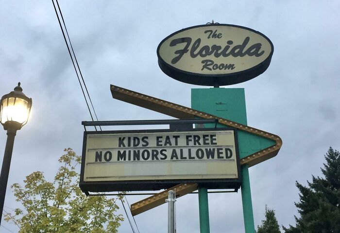 A confusing sign for The Florida Room reads "Kids Eat Free, No Minors Allowed." An example of an oddly specific rule.