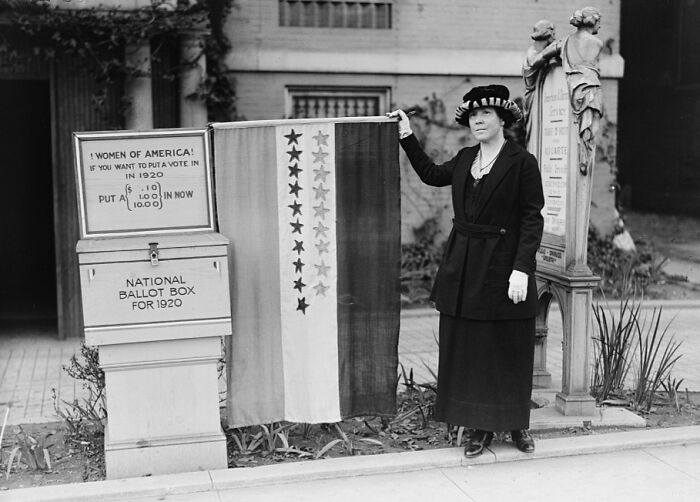 Woman standing next to a 1920 national ballot box and flag with stars, rare and interesting photos from history.