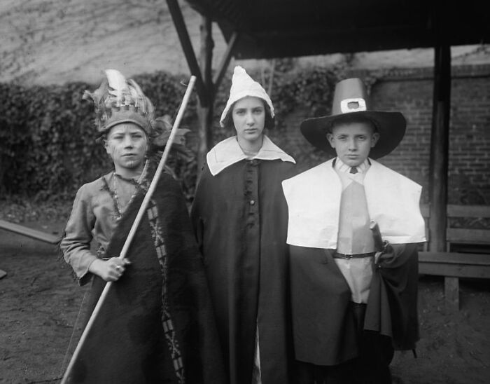 Three children dressed in historical costumes in a rare and interesting photo from a time we cannot experience.