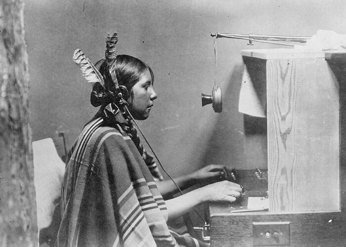 Native American woman operating early telephone equipment in a rare and interesting historic photo from a time long past.