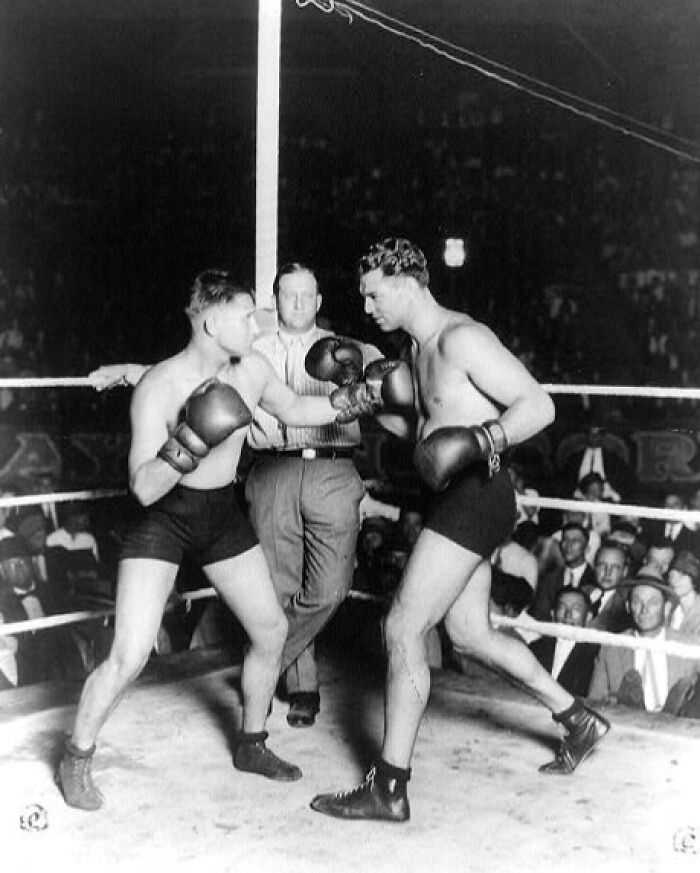 Vintage black and white photo of two boxers sparring in a ring, capturing a rare and interesting moment in history.