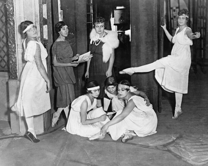 Group of women in vintage dresses practicing ballet backstage in a rare and interesting photo from a time we will never experience.
