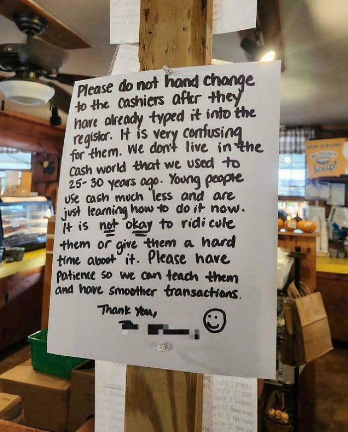 Handwritten sign asking customers to be patient with cashiers during transactions, highlighting confusing old cash customs.