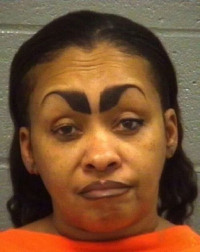 Woman with crazy eyebrows shaped like thick black arches, giving the impression they live their own lives on her face.