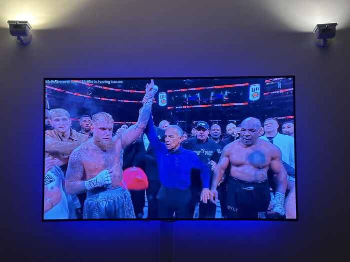 Boxers in a ring with referee raising the winner's hand, illustrating a moment of sports in a confusing or stupid time.
