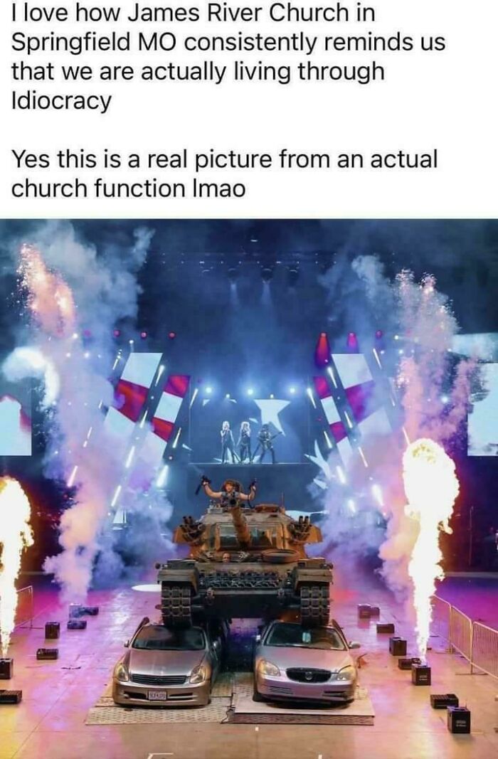 Church event with tank crushing cars, fireworks, and performers on stage, illustrating depressing moments of idiocracy.