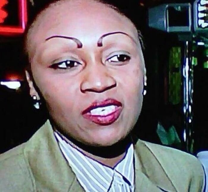 Woman with crazy eyebrows shaped like thin arches, creating a dramatic and unusual facial expression.