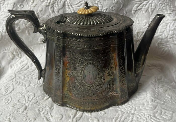 A remarkable antique silver teapot with intricate engravings and an ornate handle, a special stumble upon.