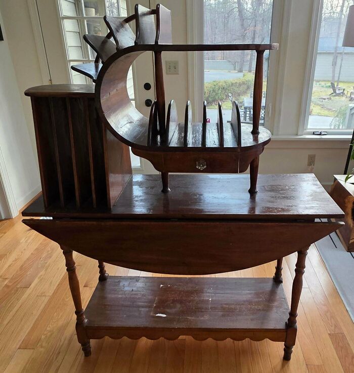 A unique wooden antique furniture piece resembling a desk with integrated shelves and a curved upper section.