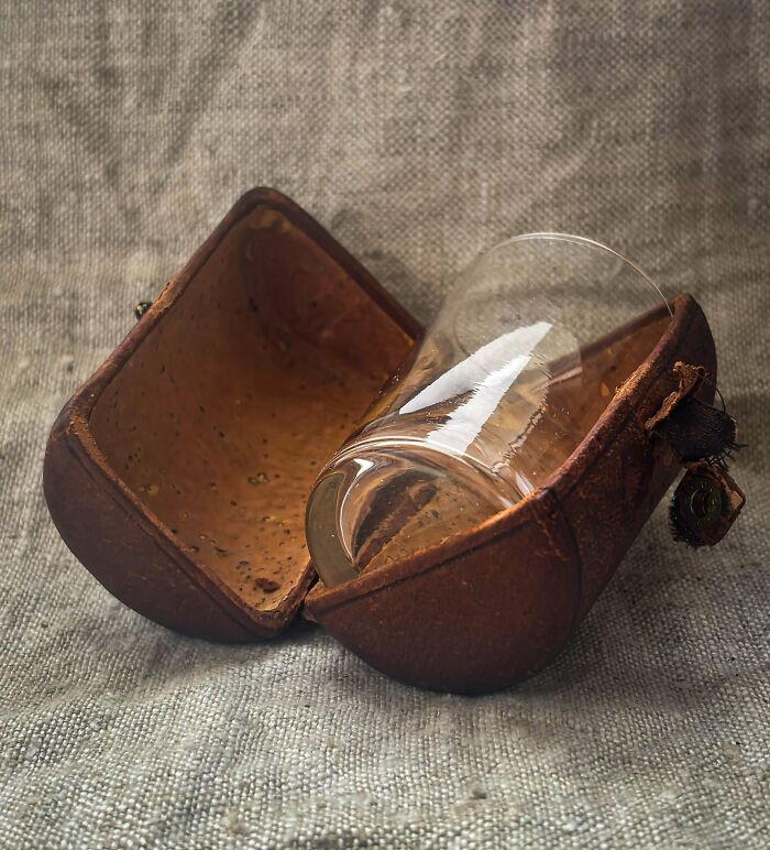A small glass tumbler nestled inside a remarkable antique leather case, a special and unique artifact.