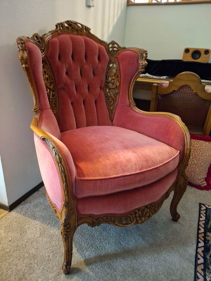 A remarkable pink velvet antique chair with ornate wooden carvings, showcasing its special, unique design.