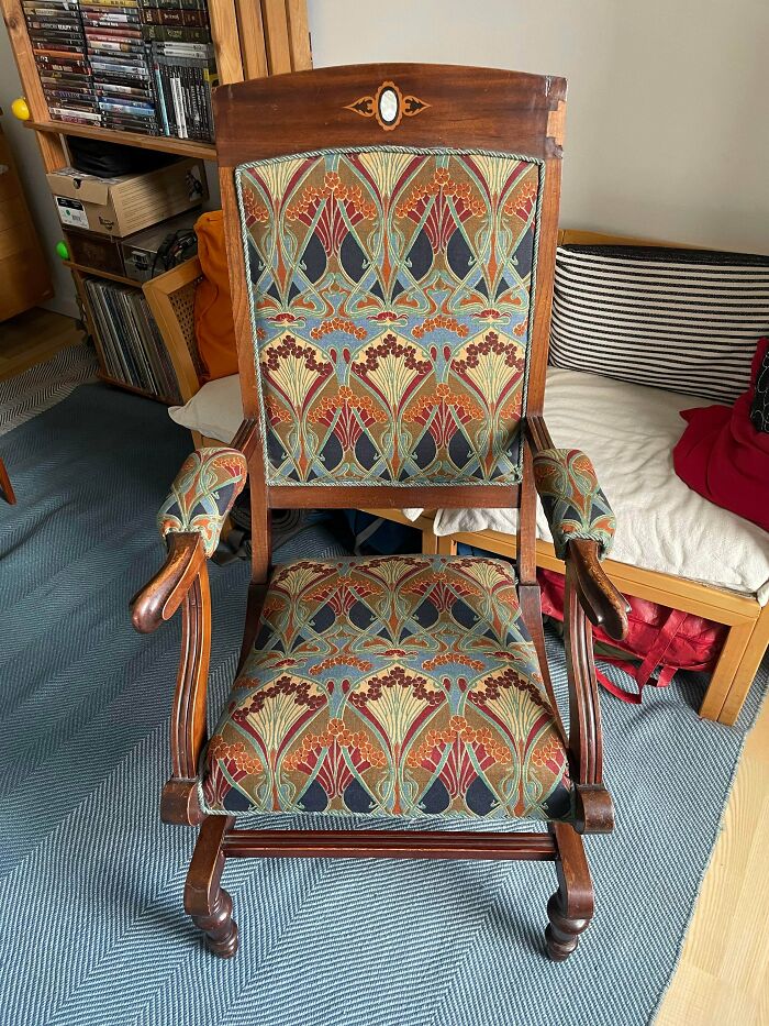 A remarkable antique wooden chair with vibrant, patterned upholstery, showcasing intricate details.