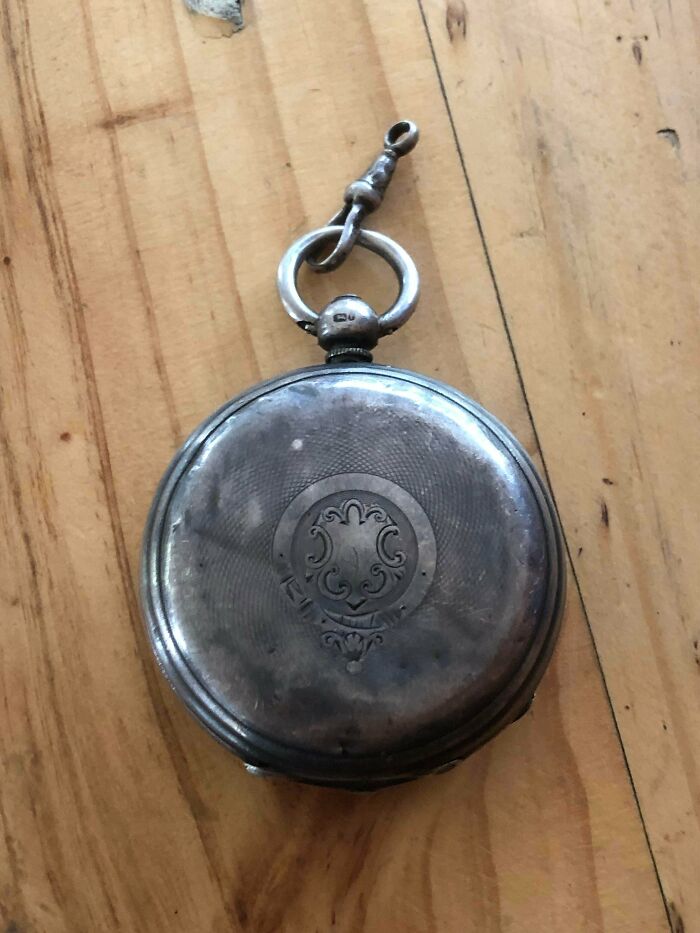 A remarkable antique silver pocket watch with intricate engravings, featuring a chain and ring attachment.