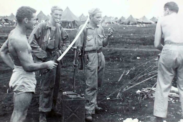 Four soldiers with a captured Japanese sword, one of many fascinating and emotional historical photos.