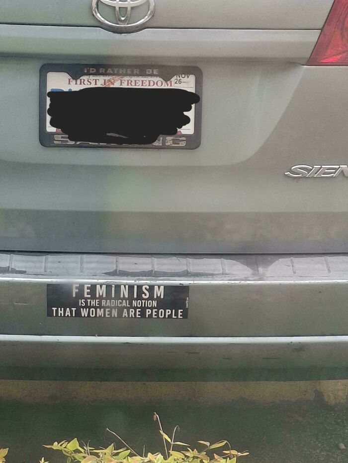 Unfiltered bumper sticker on a car saying "Feminism is the radical notion that women are people."