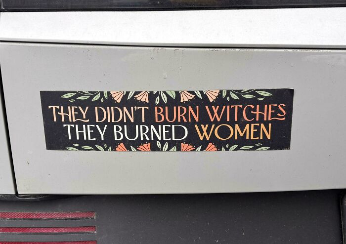 An unfiltered bumper sticker with floral accents reads, They didn't burn witches, they burned women, a truly wild bumper sticker.