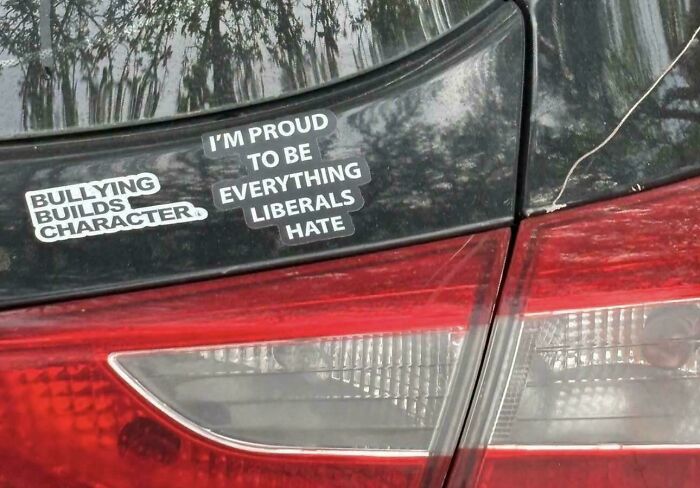 A car bumper features two funny, unfiltered bumper stickers: Bullying builds character and I'm proud to be everything liberals hate.