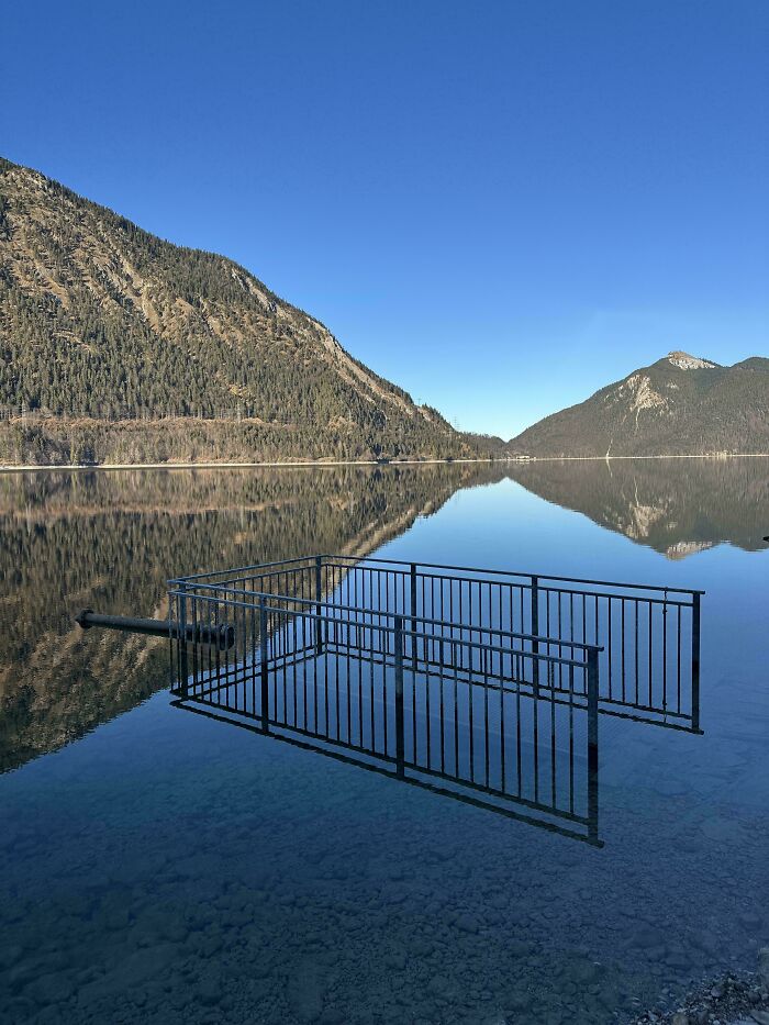 Submerged railing in clear lake water creates a misleading and confusing photo that looks like a glitch in real life.