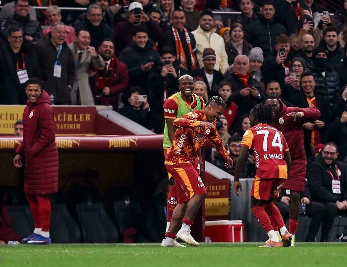 Soccer players celebrating a goal with fans cheering in the background in a scene that seems like a real-life glitch.
