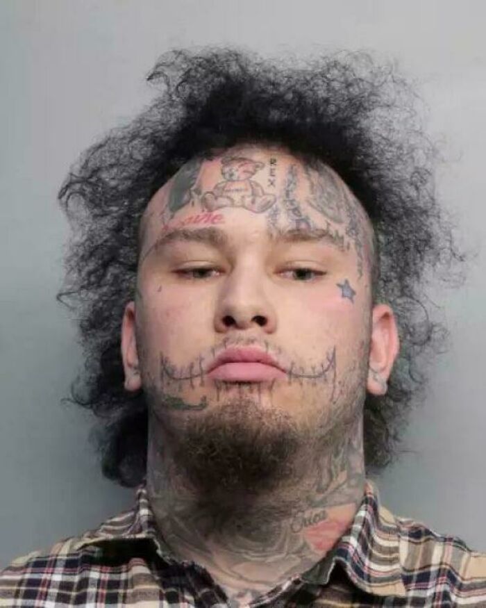 A man with a wild, untamed curly hairstyle and face tattoos, a hilariously bad hair mistake.
