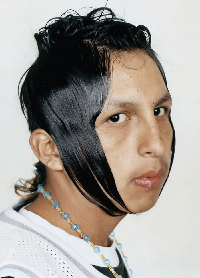 A man with a hilariously bad hair mistake, with long, stringy hair framing his face.