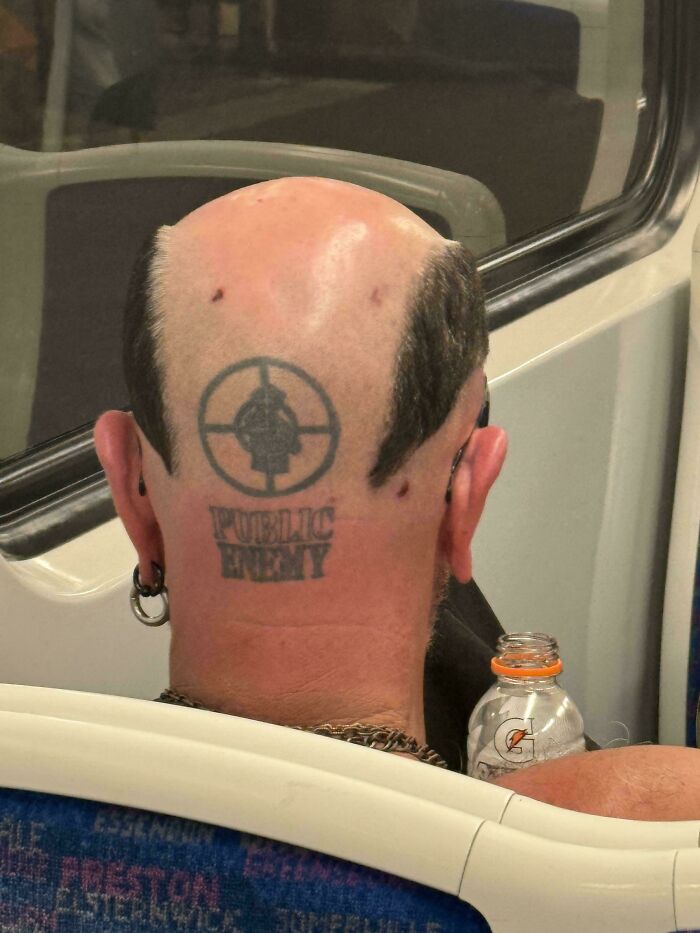 Back of a head with a large bald patch, a Public Enemy tattoo, and hair on the sides, an example of bad hair.