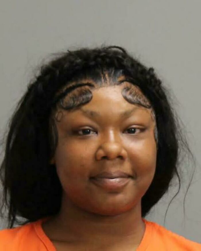 Mugshot of a woman with braided edges forming a heart shape, an example of bad hair mistakes.