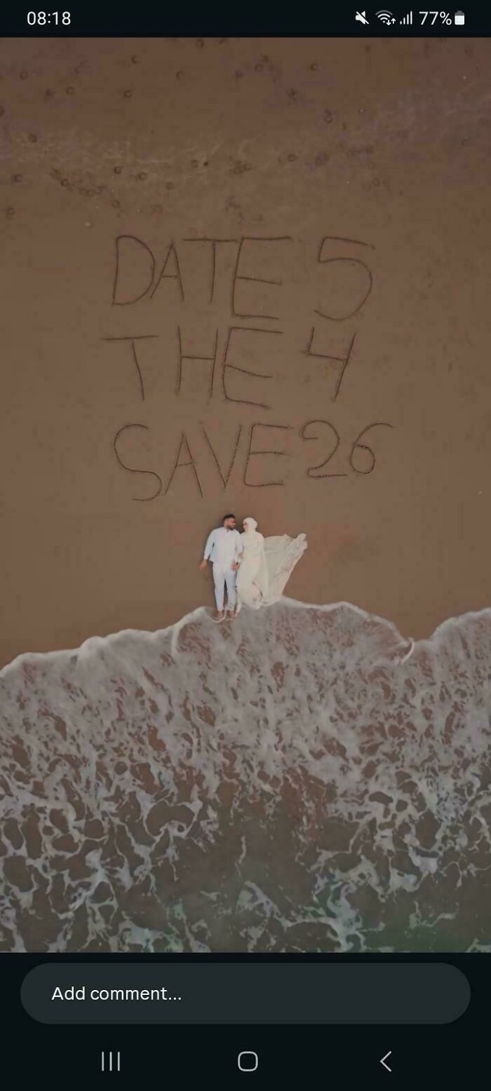 A hilariously confusing message on a beach, 'DATE 5 THE 4 SAVE 26', written in sand next to a couple.
