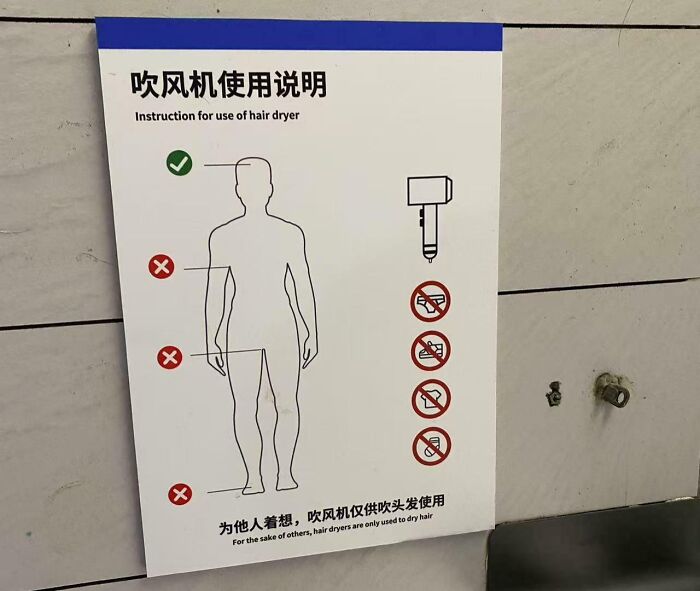 Sign showing correct and incorrect ways to use a hair dryer, a Darwin award contender moment at the gym.