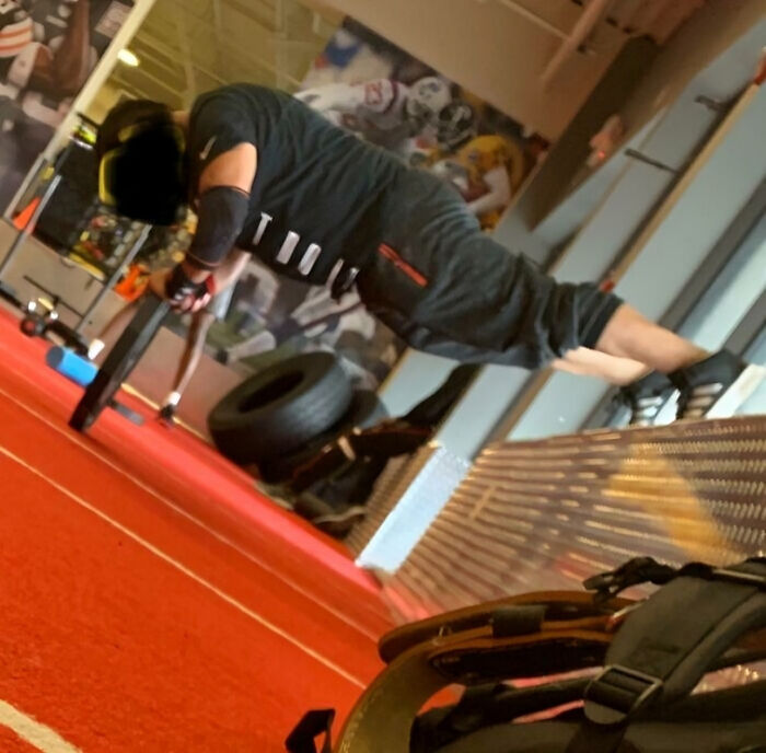 Person performing an advanced gym plank exercise with wheels, showcasing a surprising fitness move at the gym.