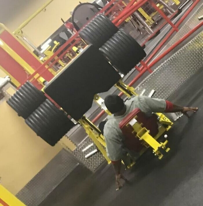 Man dangerously attempting leg press with excessive weights at gym, a shocking moment for Darwin Award contender.