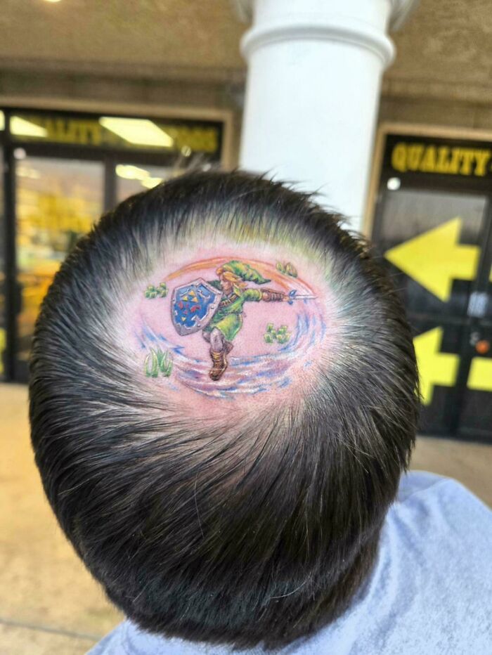 A man proudly displays a stunning tattoo of Link from Zelda on the top of his head, a happy, forever body art choice.