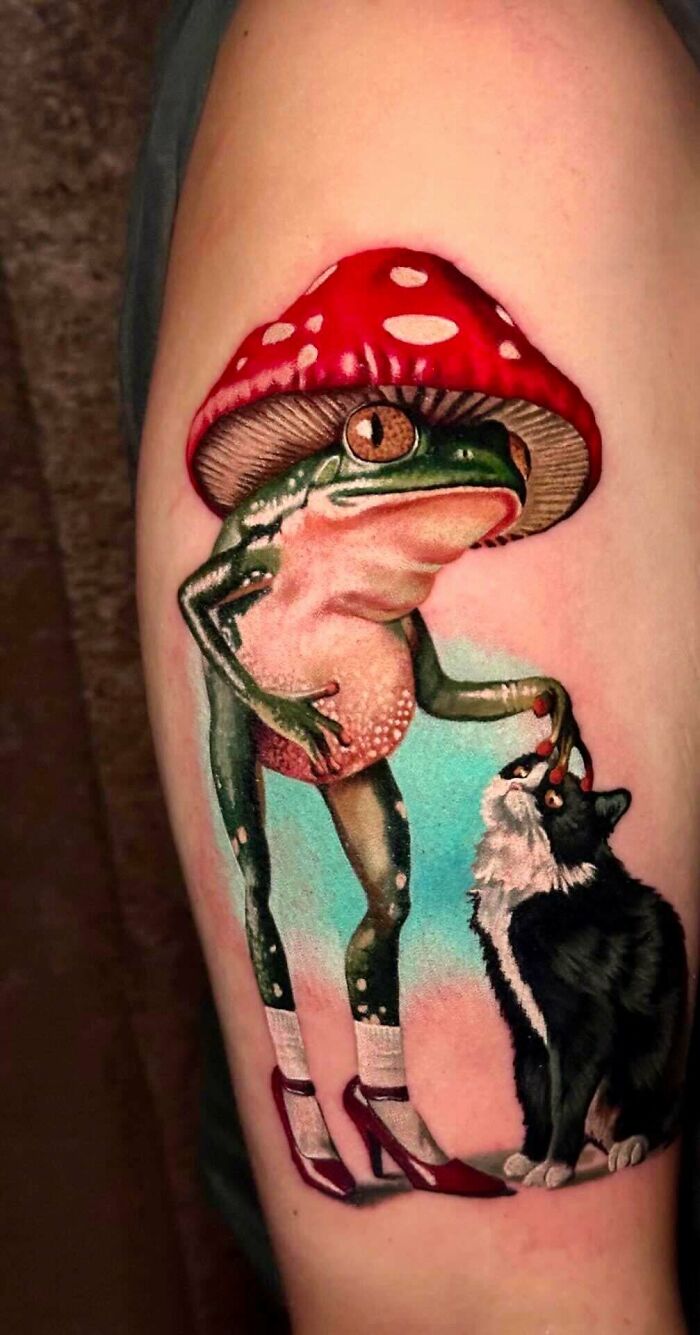 A colorful tattoo of a frog wearing a mushroom hat and high heels, feeding a black and white cat, a unique tattoo.