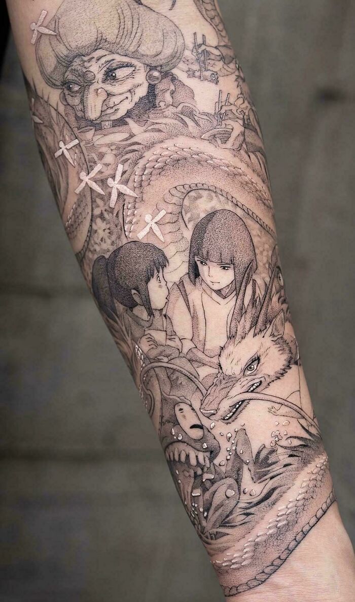 A full arm sleeve with a stunning tattoo inspired by Studio Ghibli, featuring characters and intricate fantasy elements.