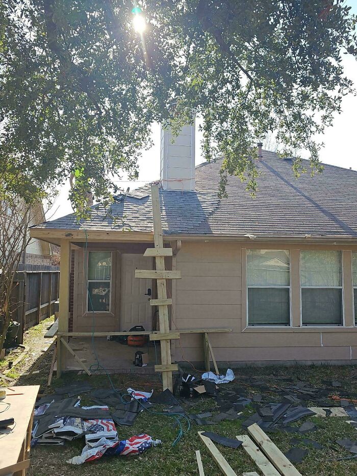 Questionable DIY project showing a wooden ladder structure leaned against a roof under repair.