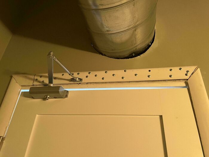Top of door frame secured with dozens of random screws as a questionable DIY project.