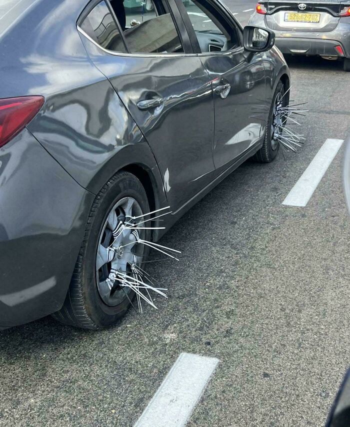 Car wheel covered in plastic zip ties in a questionable DIY project example.