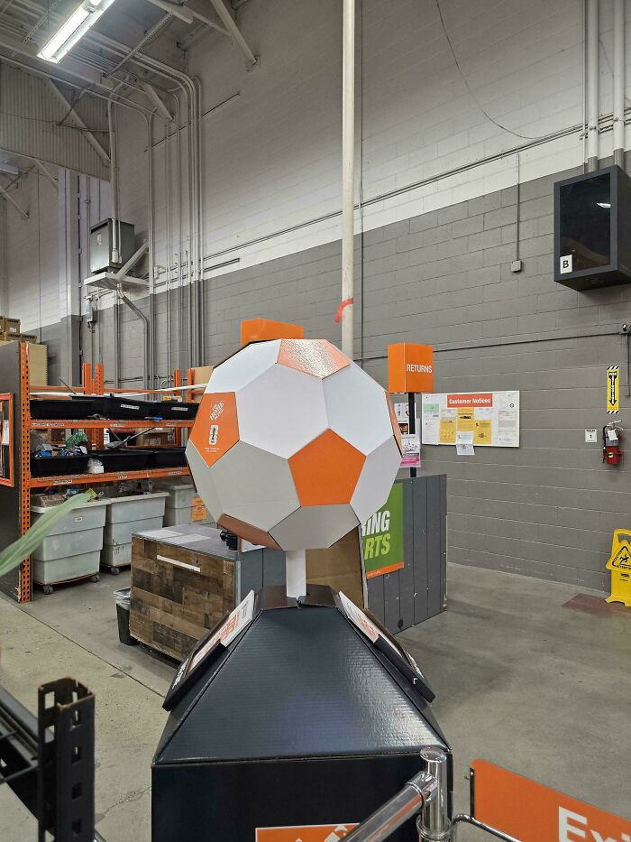An orange and white paper soccer ball display inside a store, from homedepot employees posts.