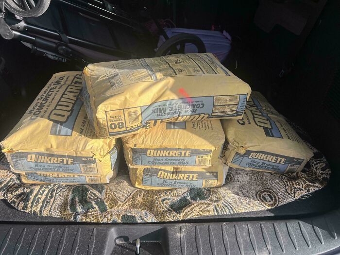Bags of concrete mix in a car trunk, highlighting the practical tasks dads often undertake.