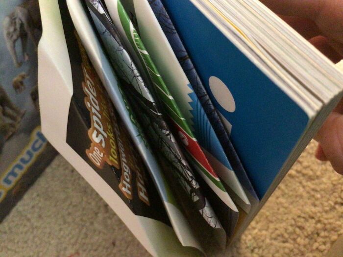 Close-up of a hand holding a folded booklet with multiple pages revealing hidden messages exposing friends online.