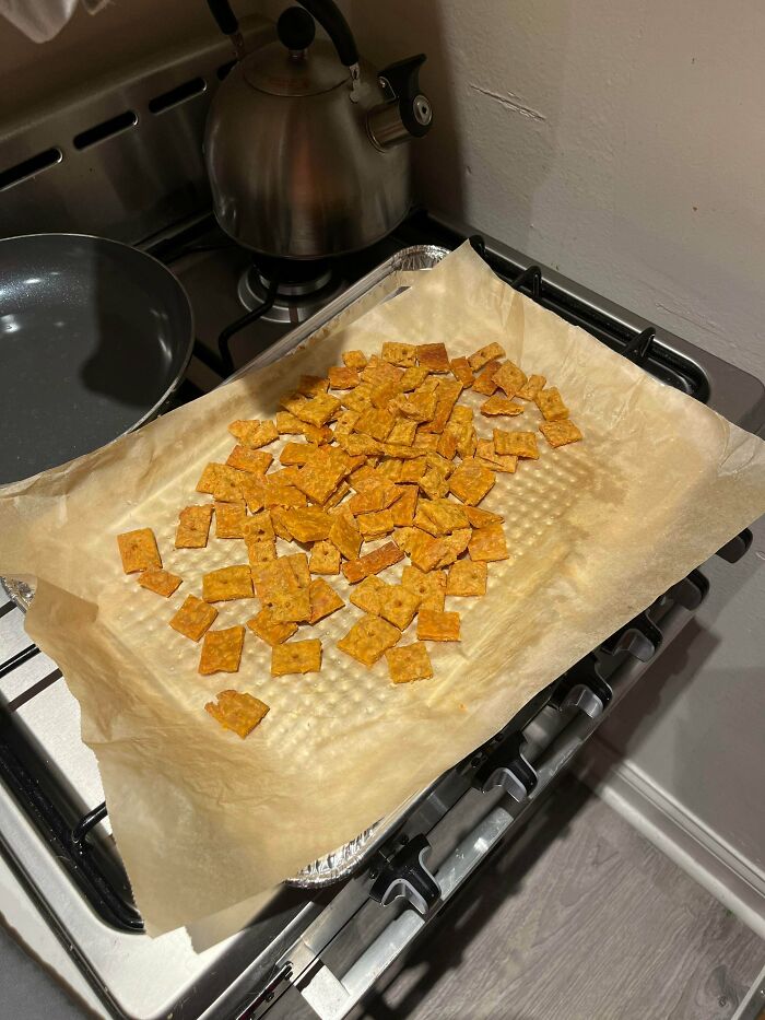A baking sheet of homemade orange crackers on a stovetop, next to a kettle and pan. Frugal tips for a whole new world.
