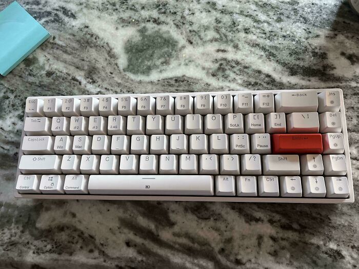 Close-up of a white computer keyboard on a marble surface, with a prominent red Enter key. Frugal tips for this economy.